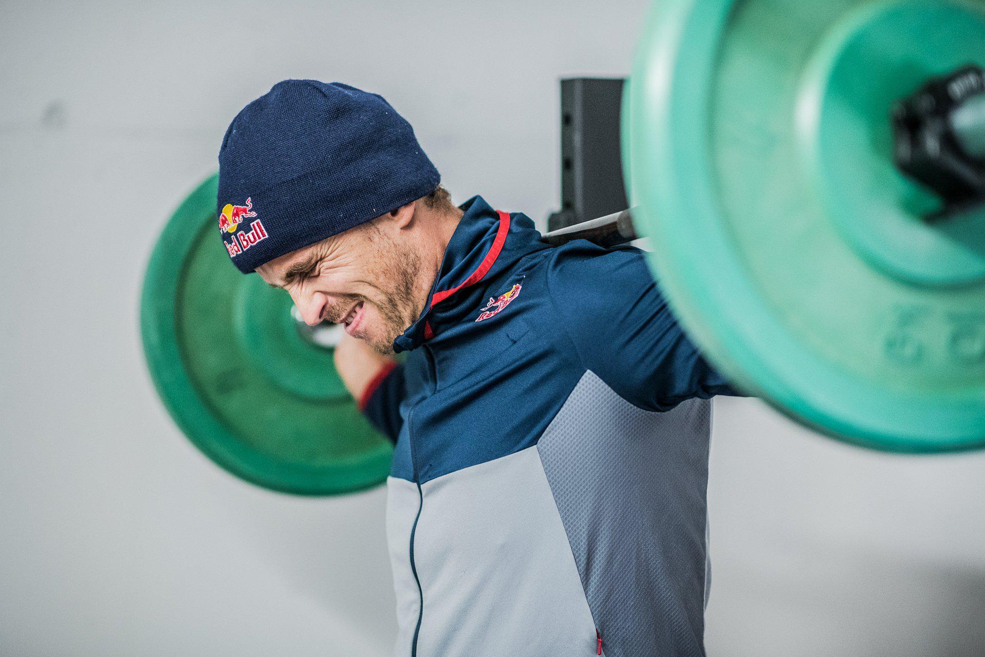 Ein Red Bull Athlet beim Training an einer Langhantel mit schweren Gewichten.